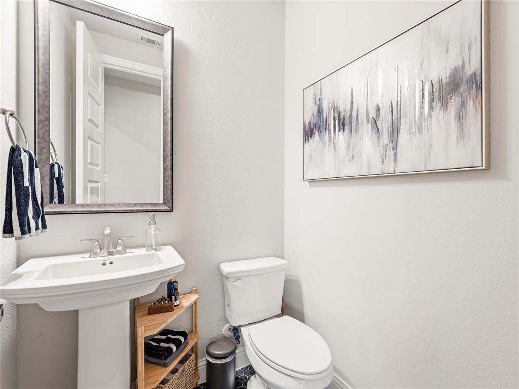15340 Crape Myrtle Road Frisco, TX 75035 - Photo 30 of 40 Pedestal sink with a polished chrome faucet, framed mirror, and a white toilet