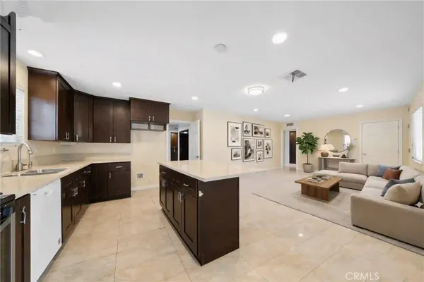 a large kitchen with stainless steel appliances a large counter top a sink a stove and a refrigerator
