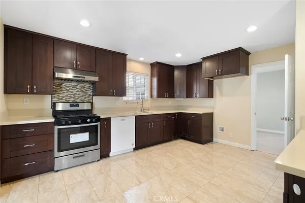 a kitchen with stainless steel appliances granite countertop wooden cabinets and a stove top oven