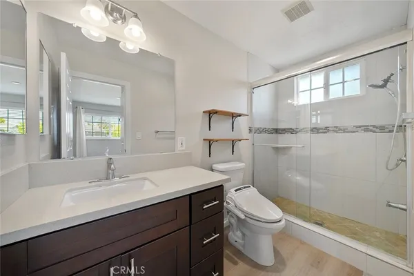 a bathroom with a sink a toilet and shower