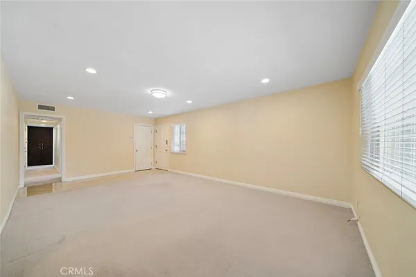 an empty room with windows and fireplace