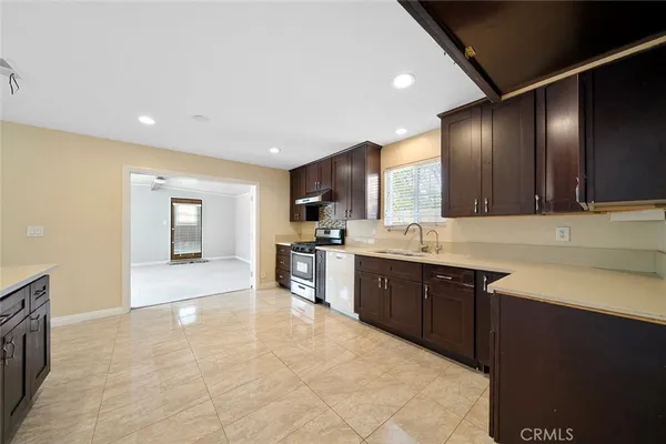 a large kitchen with stainless steel appliances granite countertop a sink and cabinets