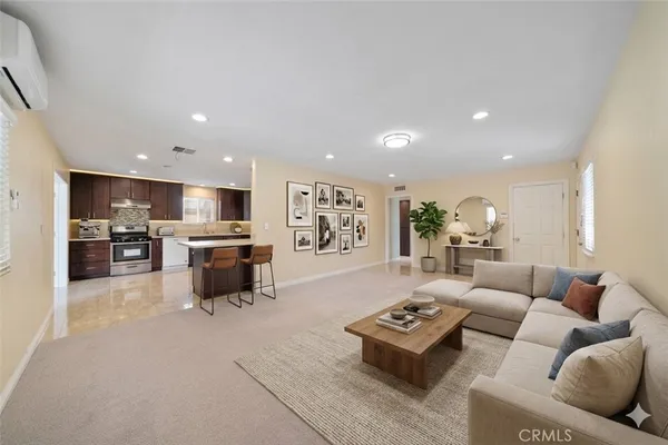 a living room with furniture kitchen view and a chandelier
