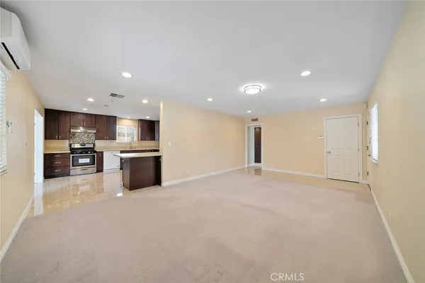 a view of kitchen with kitchen island white cabinets and stainless steel appliances
