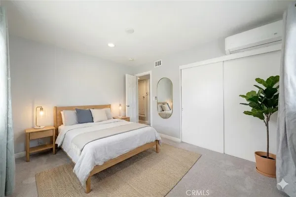 a bedroom with a bed and a potted plant