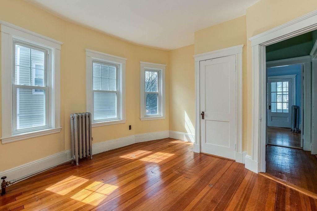73 Westbourne Street Boston, MA 02131 - Photo 14 of 41 an empty room with wooden floor and windows