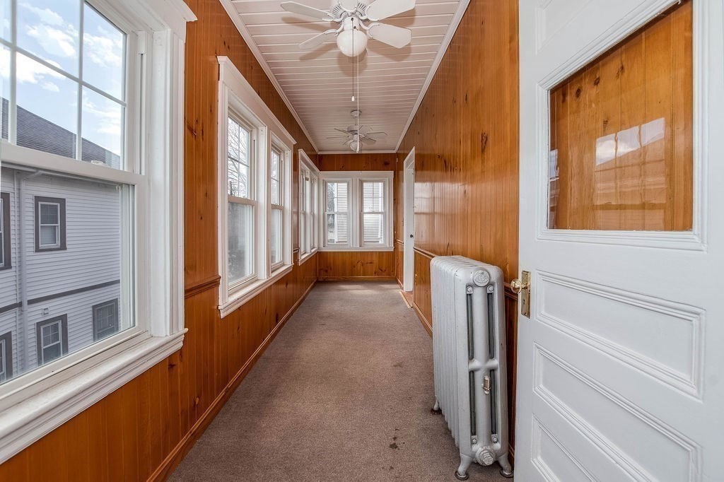 73 Westbourne Street Boston, MA 02131 - Photo 23 of 41 a view of a hallway with a large window and a chandelier