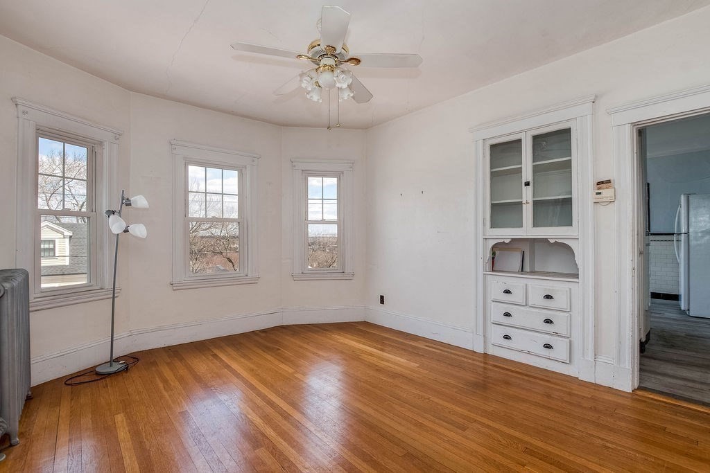 73 Westbourne Street Boston, MA 02131 - Photo 6 of 41 a view of empty room with wooden floor and fan