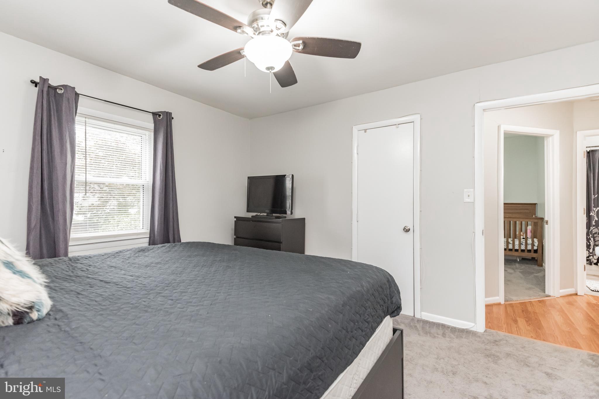 1729 Ridgely Road Edgewater, MD 21037 - Photo 20 of 29 a bedroom with a bed and a chandelier