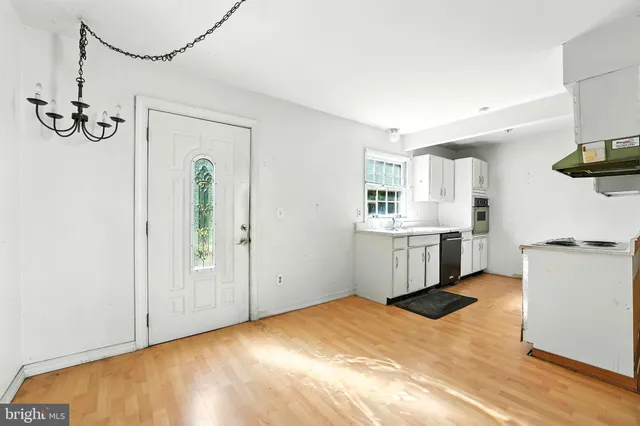 a view of a kitchen with wooden floor and a window