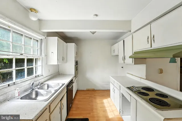 a kitchen with a sink stove top oven and cabinets