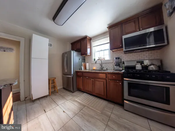 a kitchen with stainless steel appliances granite countertop a stove microwave and refrigerator