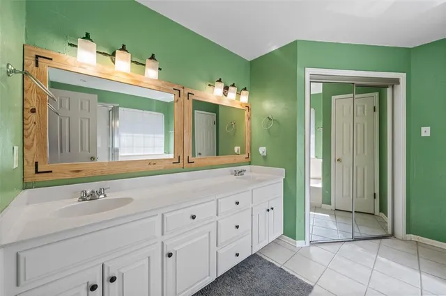 a bathroom with a double vanity sink and a mirror