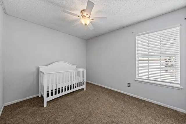 a view of a room with a ceiling fan and a window