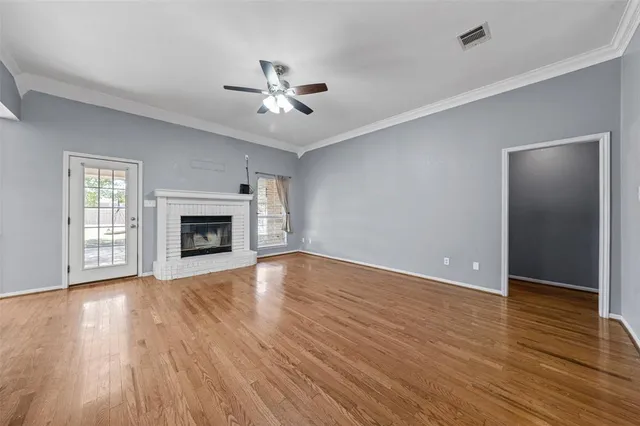 a view of empty room with wooden floor and fireplace