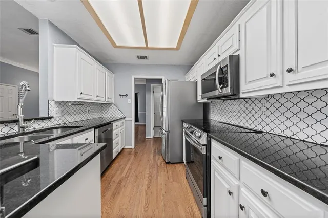 a kitchen with stainless steel appliances granite countertop a stove and a sink