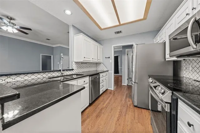a kitchen with stainless steel appliances granite countertop a sink stove and refrigerator