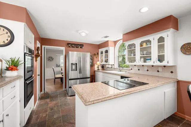 a kitchen with stainless steel appliances granite countertop a sink and a refrigerator