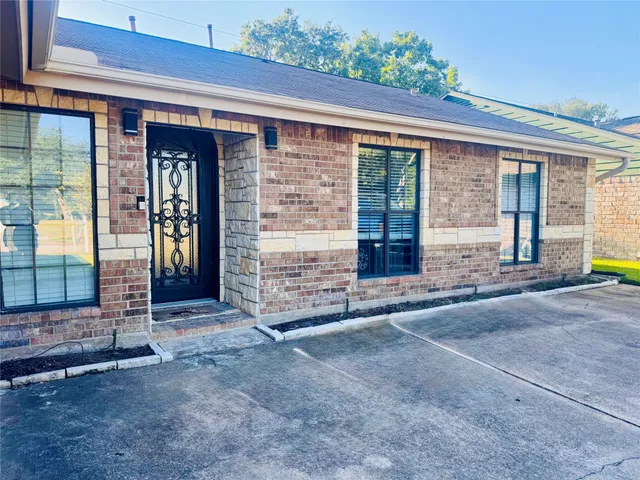 a view of a brick house with large windows