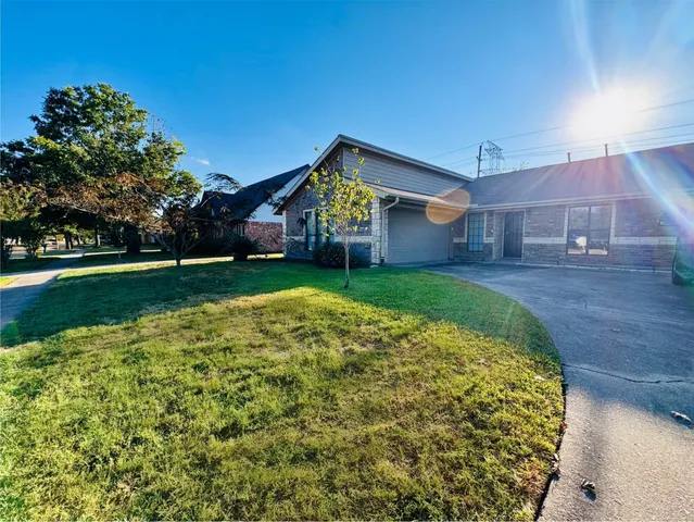 a big yard with table and chairs under an umbrella