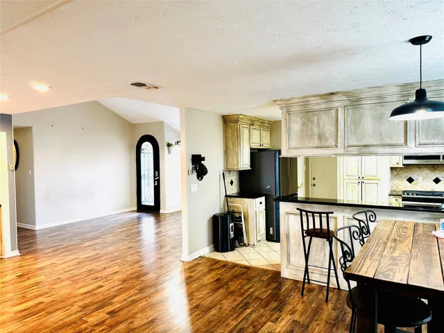 a living room with furniture a flat screen tv and kitchen view