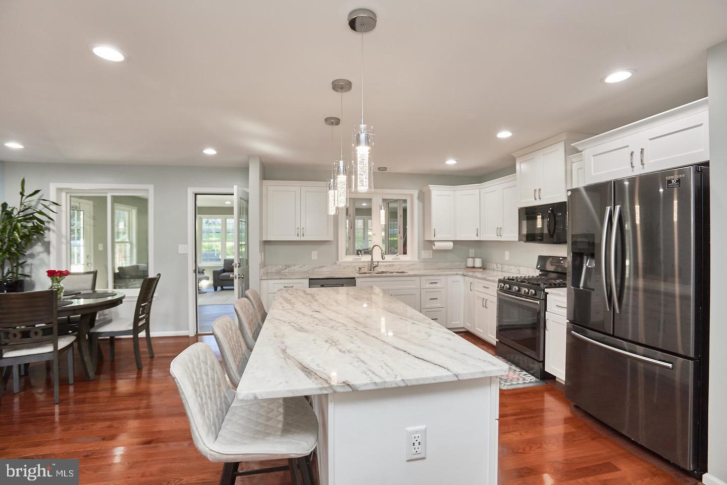 1007 Venice Drive Silver Spring, MD 20904 - Photo 12 of 39 a large kitchen with kitchen island white cabinets and stainless steel appliances