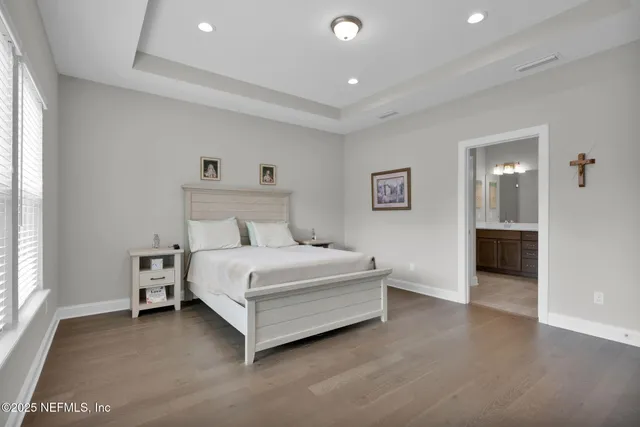 a spacious bedroom with a bed and a view of kitchen