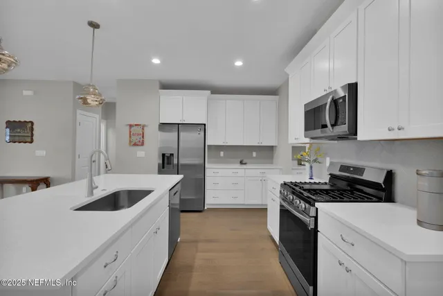 a kitchen that has a sink a stove and refrigerator