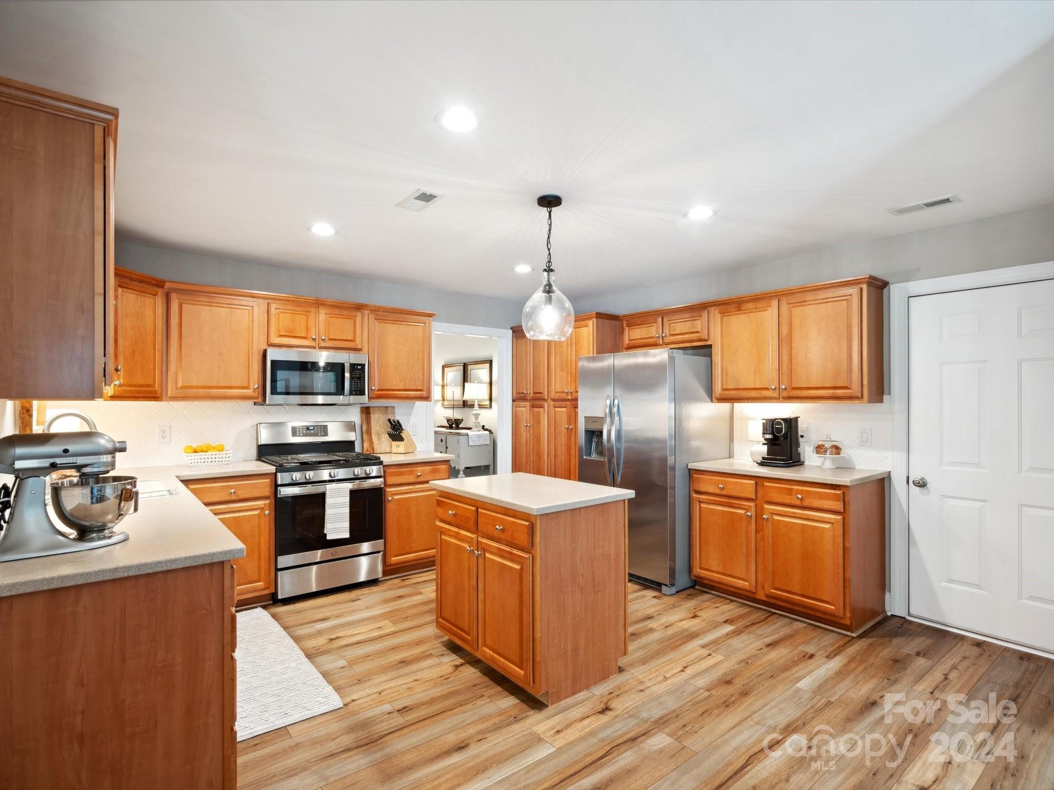 166 Zimmerman Drive Fort Mill, SC 29708 - Photo 12 of 30 a kitchen with stainless steel appliances granite countertop a stove top oven a refrigerator a sink and dishwasher with wooden floor