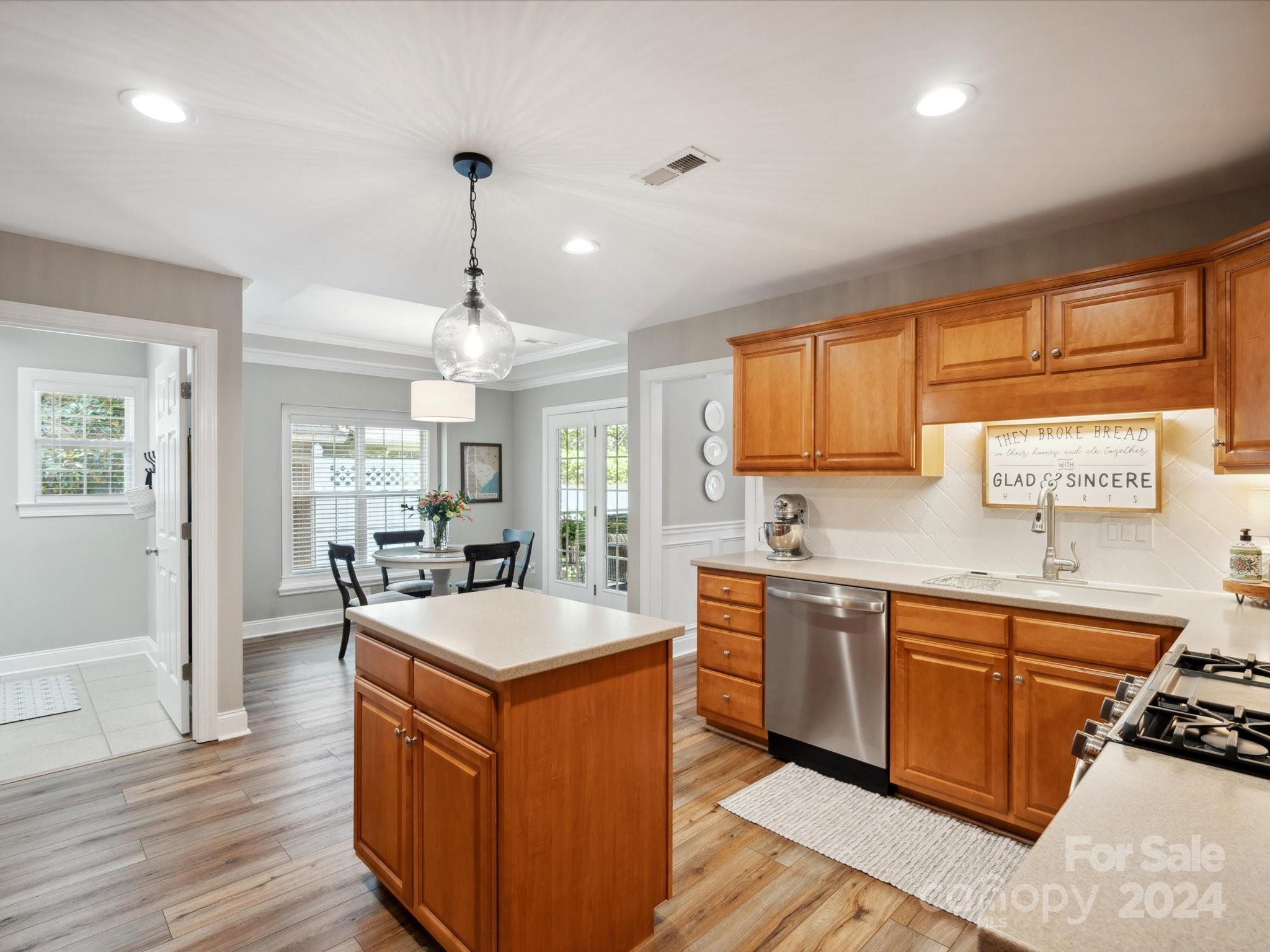 166 Zimmerman Drive Fort Mill, SC 29708 - Photo 14 of 30 a large kitchen with stainless steel appliances granite countertop a sink dishwasher a stove and a dining table with wooden floor