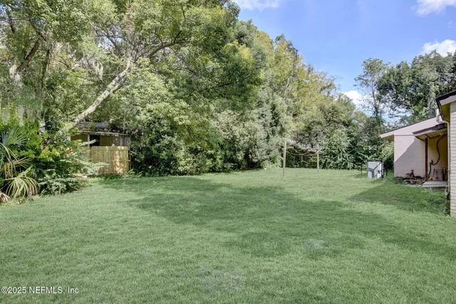 a view of a field of grass and trees