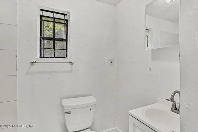 a bathroom with a toilet sink and mirror