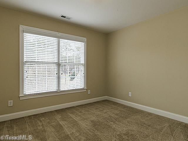 5403 Gray Leigh Drive Oak Ridge, NC 27310 - Photo 12 of 16 4th Bedroom. The 4th bedroom receives lots of light from the large windows. Features neutral paint and carpet.