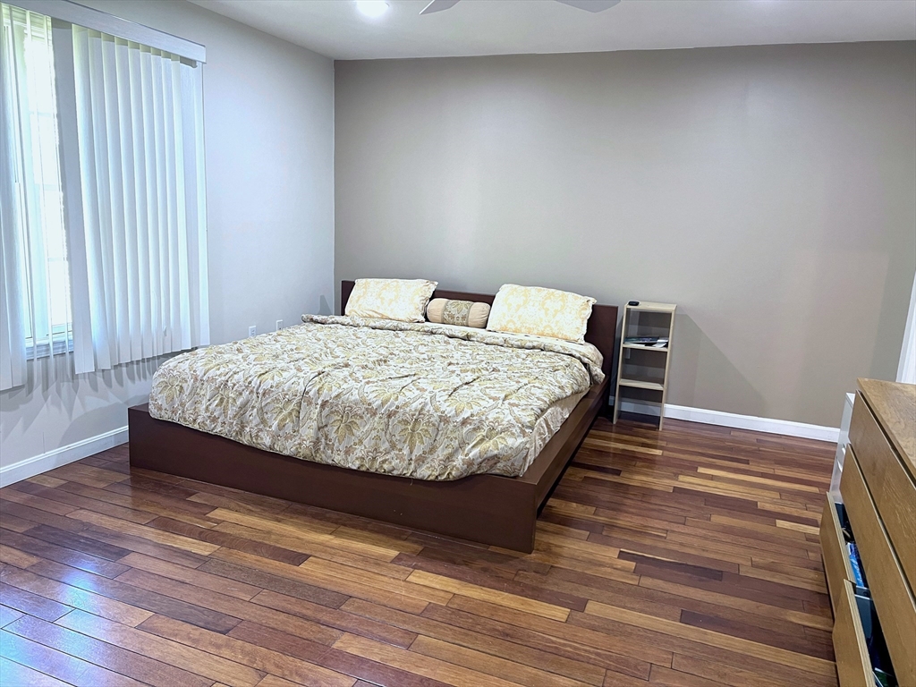 42 Evergreen Circle, Unit 42 Canton, MA 02021 - Photo 13 of 26 a bedroom with a bed and wooden floor