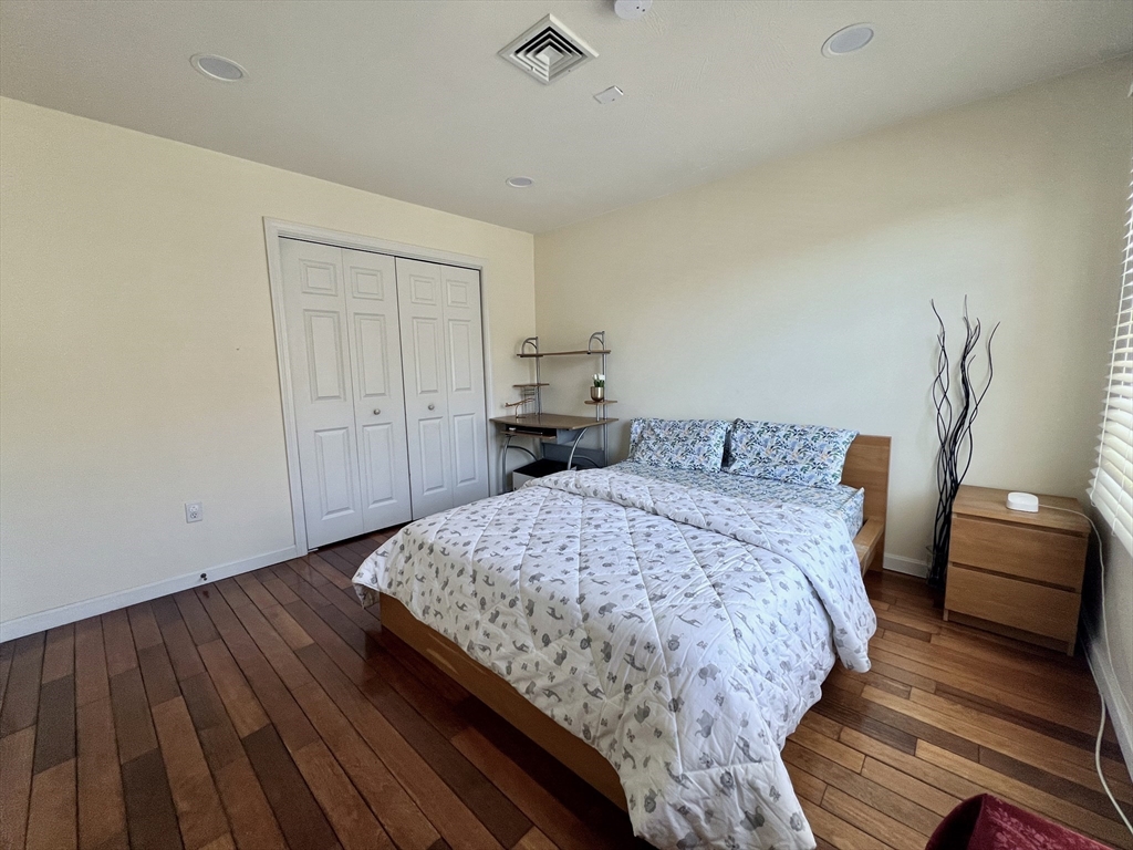 42 Evergreen Circle, Unit 42 Canton, MA 02021 - Photo 17 of 26 a bedroom with a bed and wooden floor