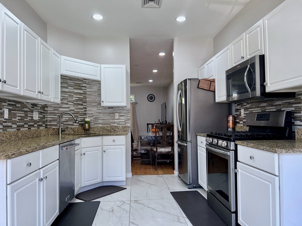 42 Evergreen Circle, Unit 42 Canton, MA 02021 - Photo 7 of 26 a kitchen with stainless steel appliances granite countertop a refrigerator and a stove top oven