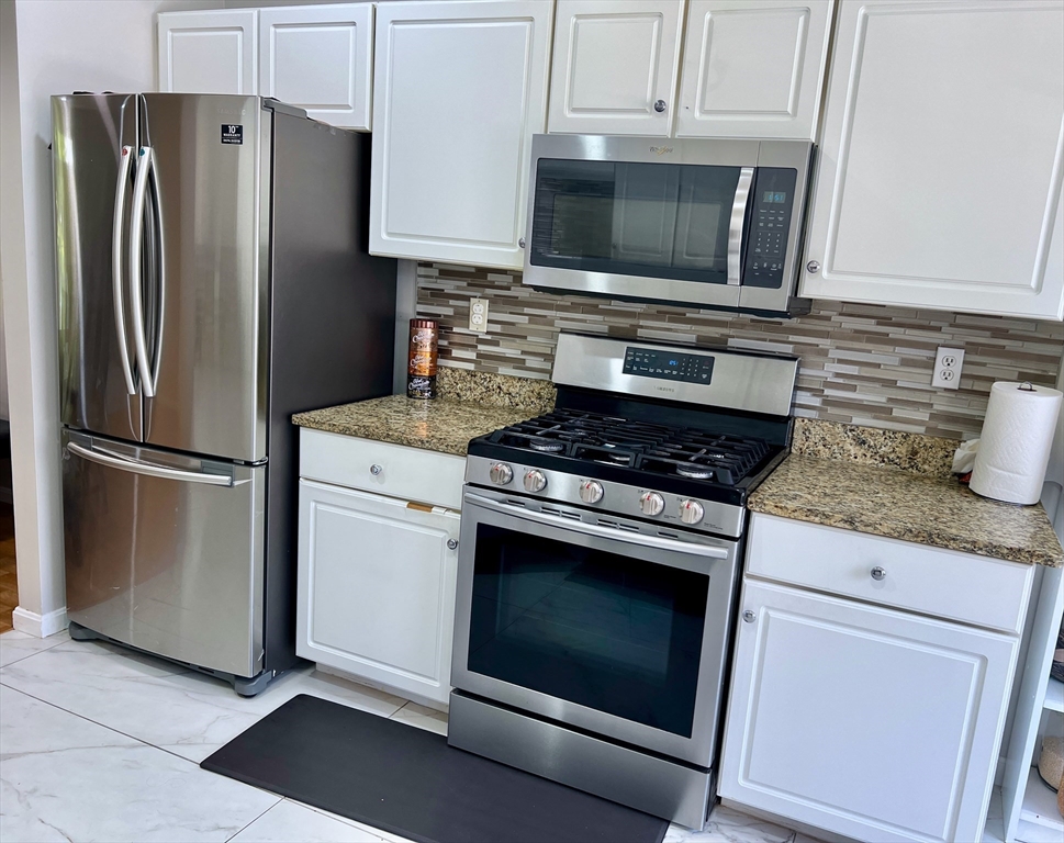 42 Evergreen Circle, Unit 42 Canton, MA 02021 - Photo 8 of 26 a kitchen with stainless steel appliances granite countertop a stove microwave and refrigerator