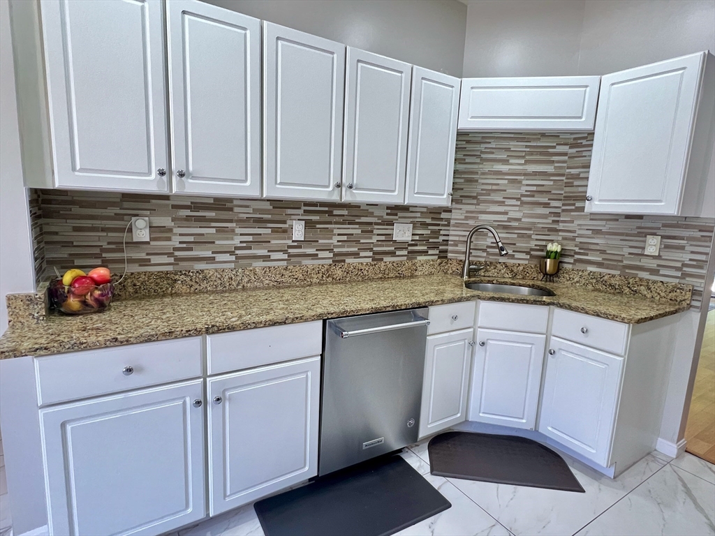 42 Evergreen Circle, Unit 42 Canton, MA 02021 - Photo 9 of 26 a kitchen with stainless steel appliances granite countertop white cabinets sink and granite counter tops