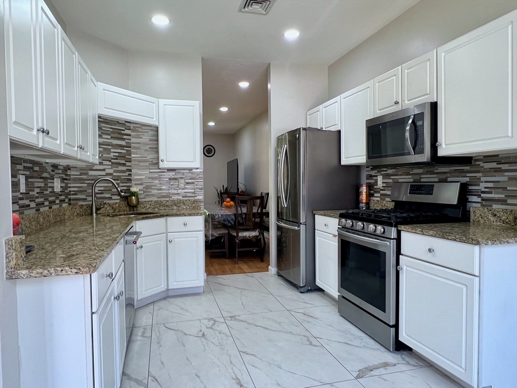 42 Evergreen Circle, Unit 42 Canton, MA 02021 - Photo 10 of 26 a kitchen with stainless steel appliances granite countertop a stove a sink and a microwave