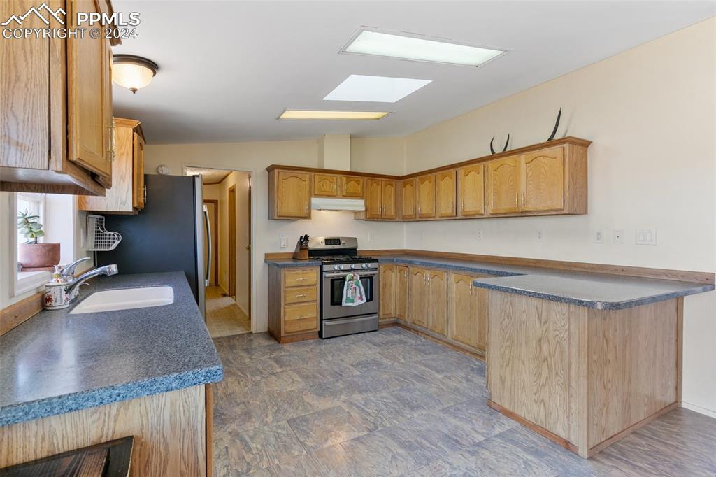 18830 Kevin's View Peyton, CO 80831 - Photo 16 of 37 Kitchen offers loads of natural light and boasts plenty of counter space including a small breakfast bar