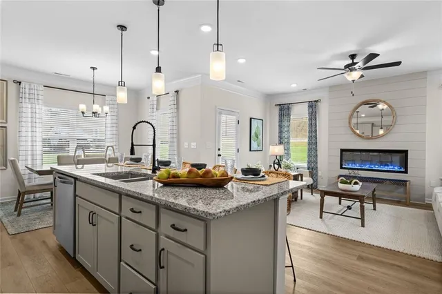 a kitchen with granite countertop a sink a counter space and living room view