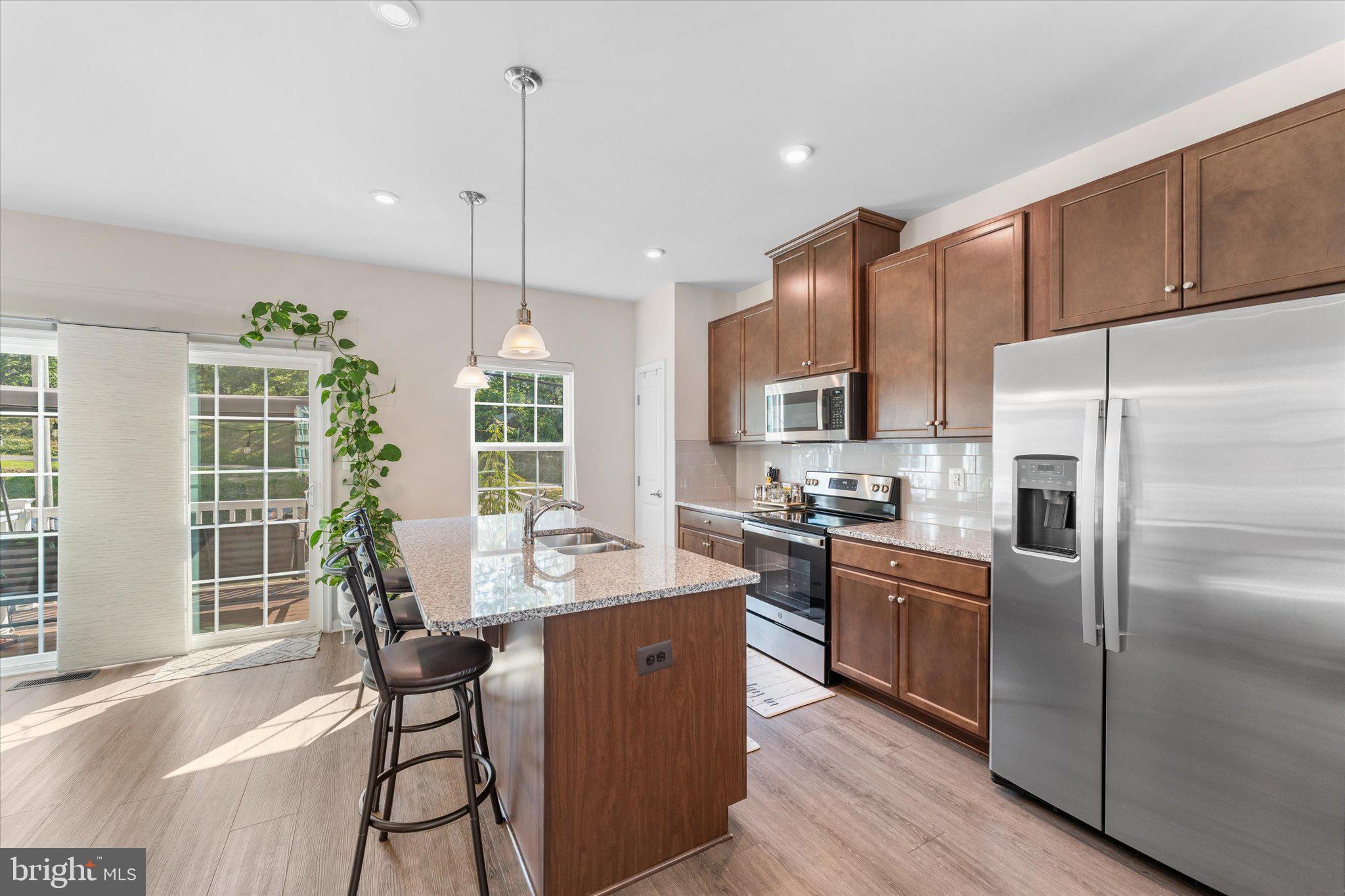 1776 Scenic Loop Culpeper, VA 22701 - Photo 6 of 36 a kitchen with stainless steel appliances granite countertop a refrigerator a sink dishwasher a stove and a dining table with wooden floor