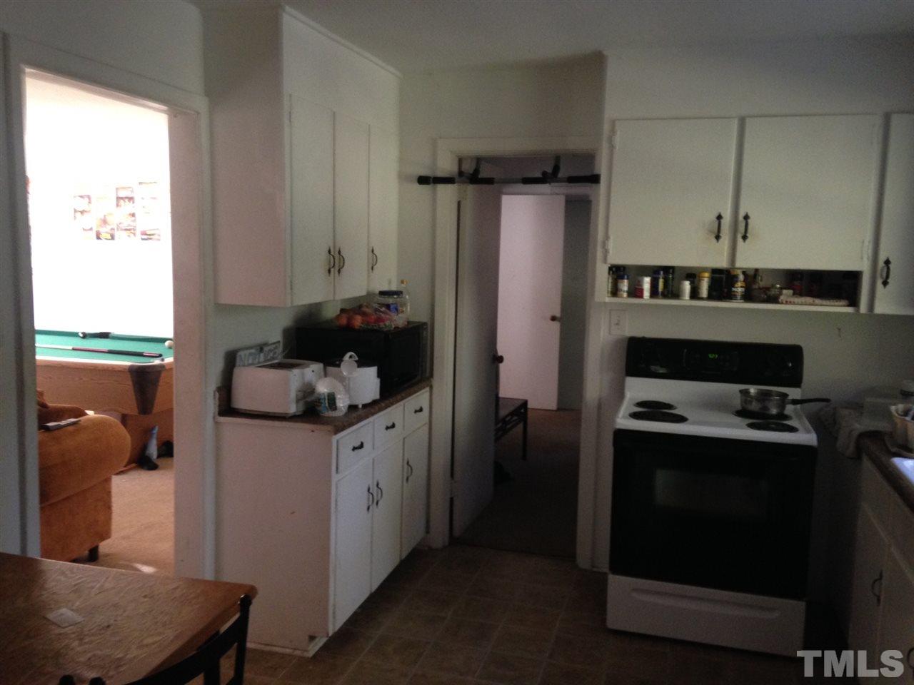 2124 Lizard Lick Road Zebulon, NC 27597 - Photo 7 of 9 a kitchen with a refrigerator and a stove