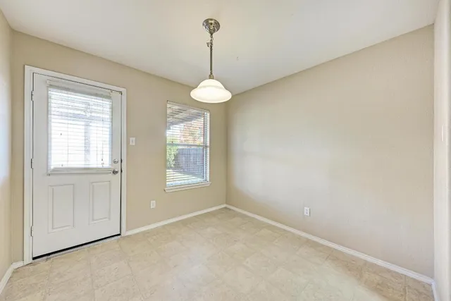 an empty room with windows and ceiling fan