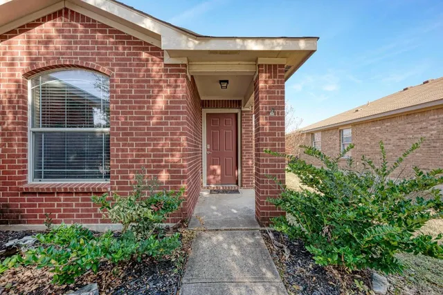 an empty room with wooden floor chandelier fan and windows