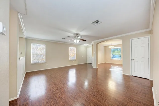 an empty room with wooden floor and windows