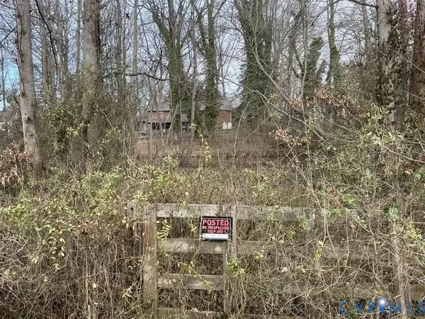 a sign that is sitting in front of a tree