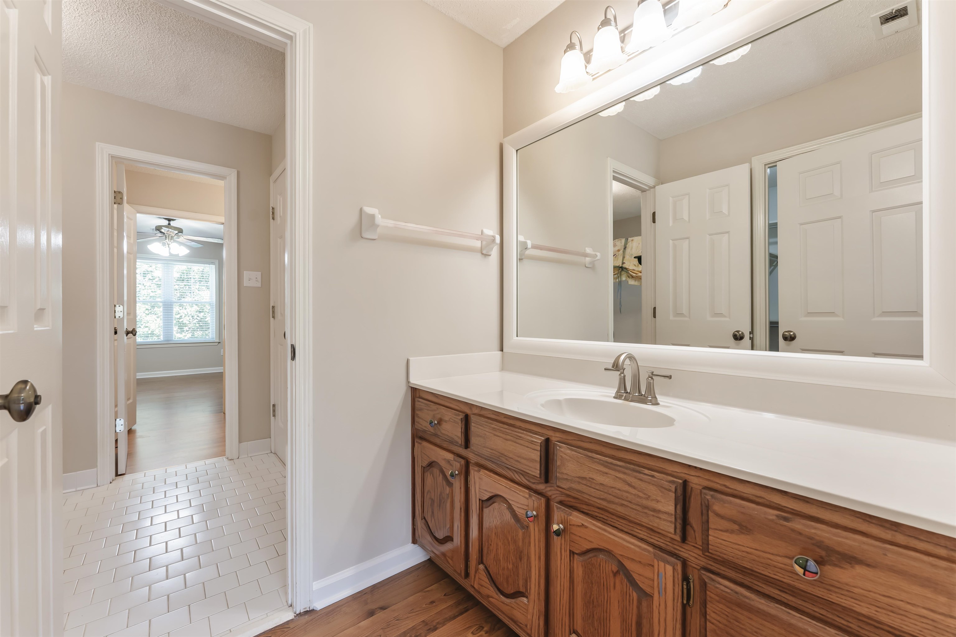 4279 High Plains Road Bartlett, TN 38135 - Photo 23 of 37 Bathroom vanity featuring a single basin sink, white countertop, and wood-finish cabinetry