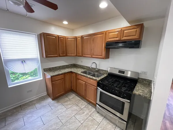 a kitchen with stainless steel appliances granite countertop a stove a sink and a microwave
