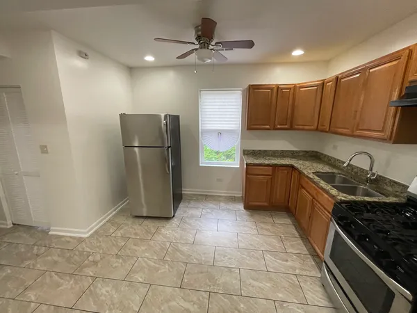 a kitchen with stainless steel appliances granite countertop a refrigerator a sink a stove a microwave and island